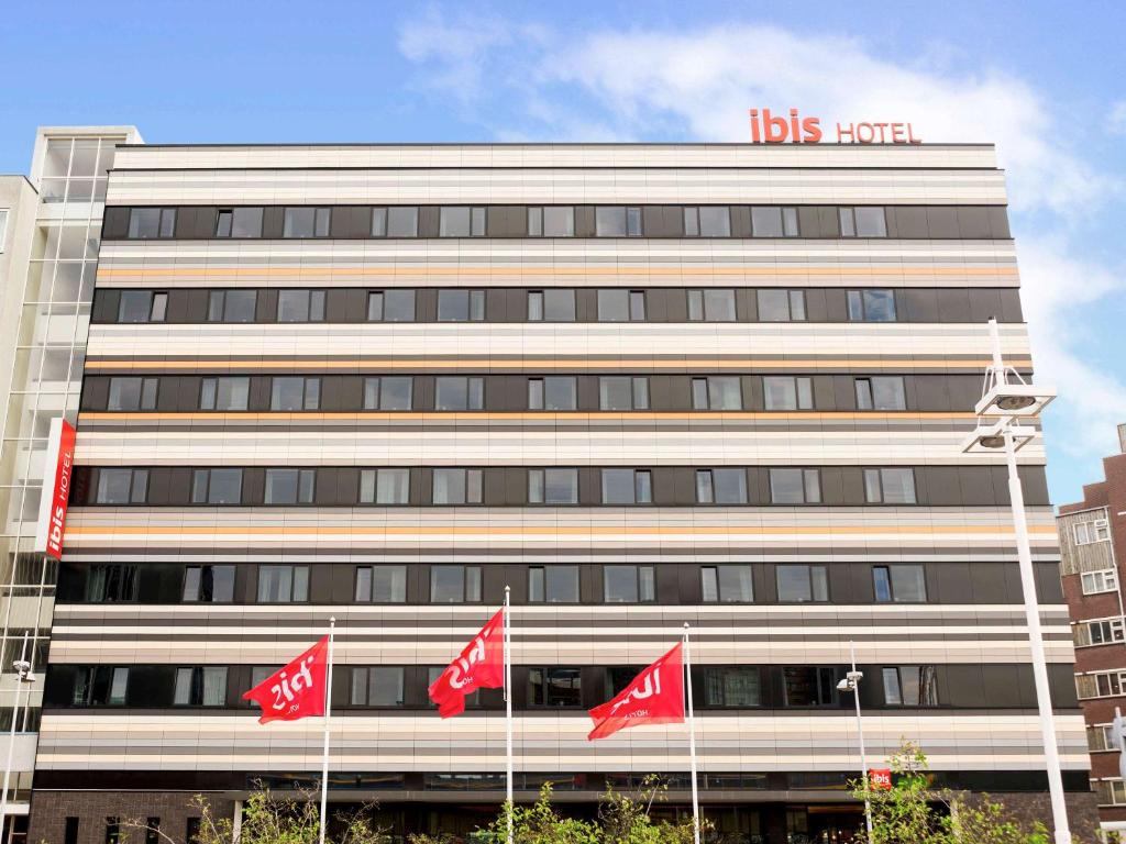a building with red canadian flags in front of it at ibis Leiden Centre in Leiden