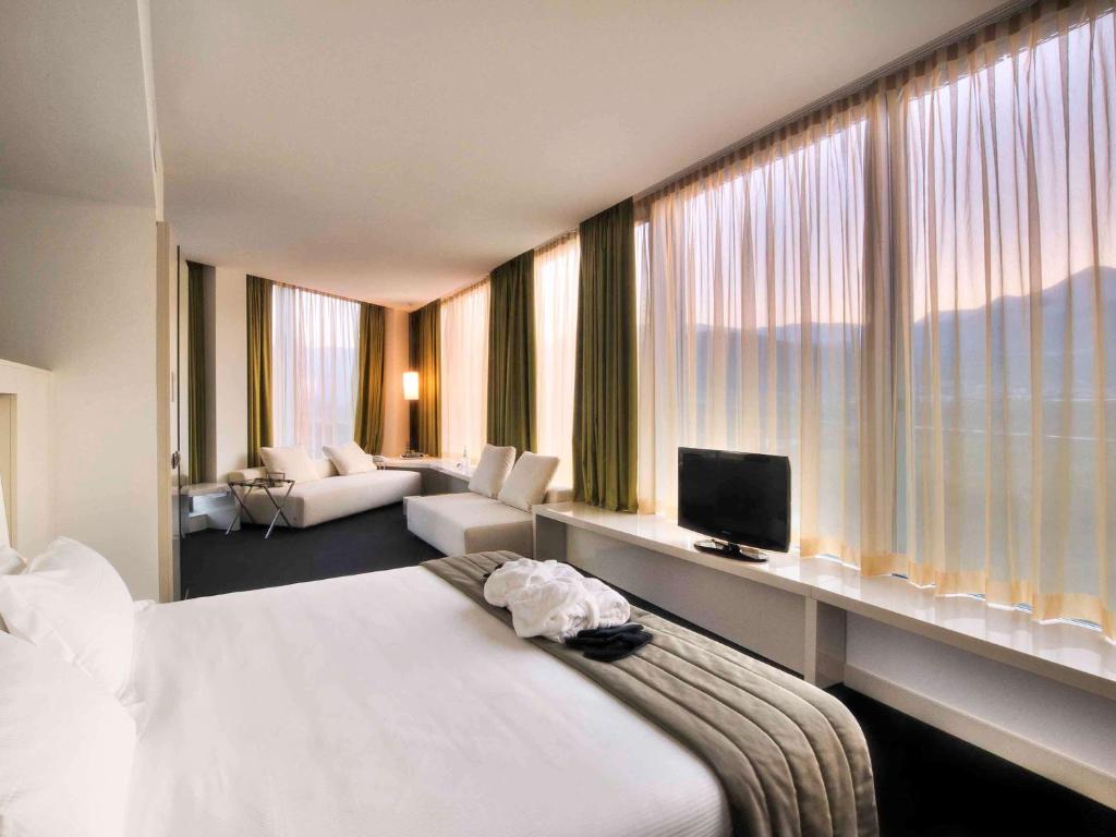 a hotel room with a bed and a large window at Mercure Nerocubo Rovereto in Rovereto