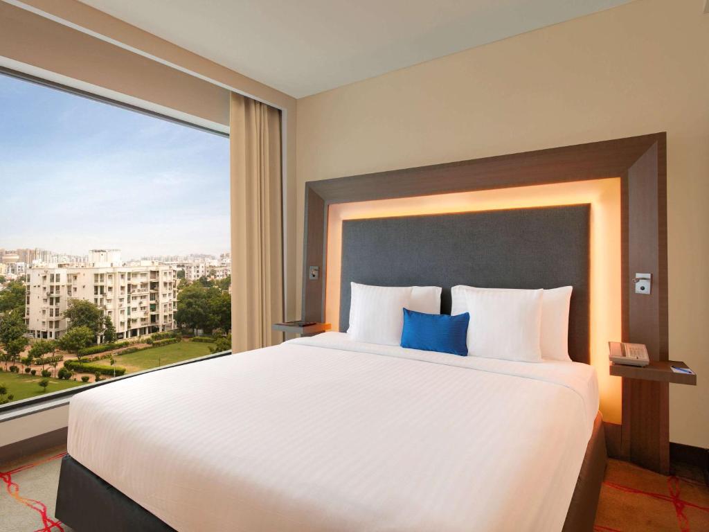 Postel nebo postele na pokoji v ubytování Novotel Ahmedabad
