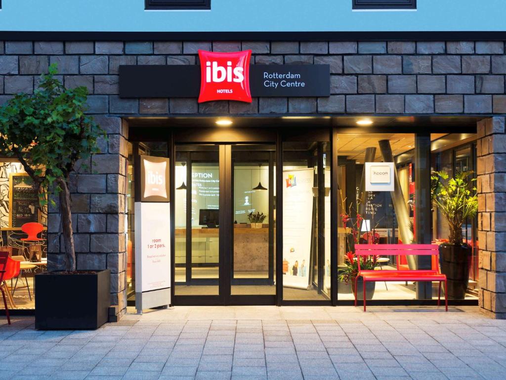 a store front with a red bench in front of it at ibis Rotterdam City Centre in Rotterdam