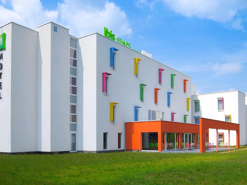 un hôtel avec un bâtiment doté de fenêtres colorées dans l'établissement ibis Styles Nivelles, à Nivelles