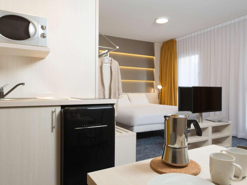a room with a kitchen and a living room at ibis Styles Nivelles in Nivelles