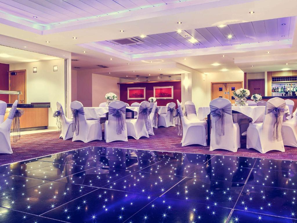 a set up for a wedding in a ballroom with tables and chairs at Mercure Glasgow City Hotel in Glasgow