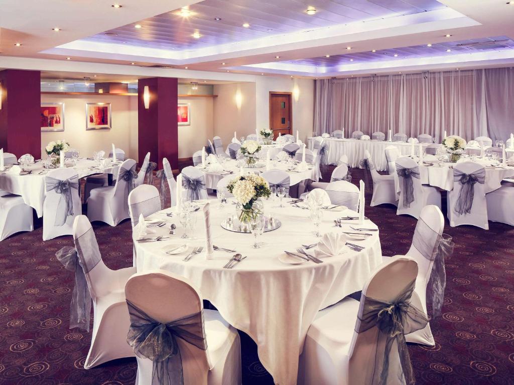 a banquet room with white tables and chairs at Mercure Glasgow City Hotel in Glasgow