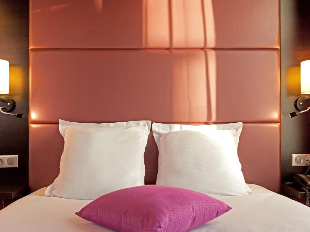 1 cama con 2 almohadas y almohada rosa en Ibis Styles Paris Pigalle Montmartre en París