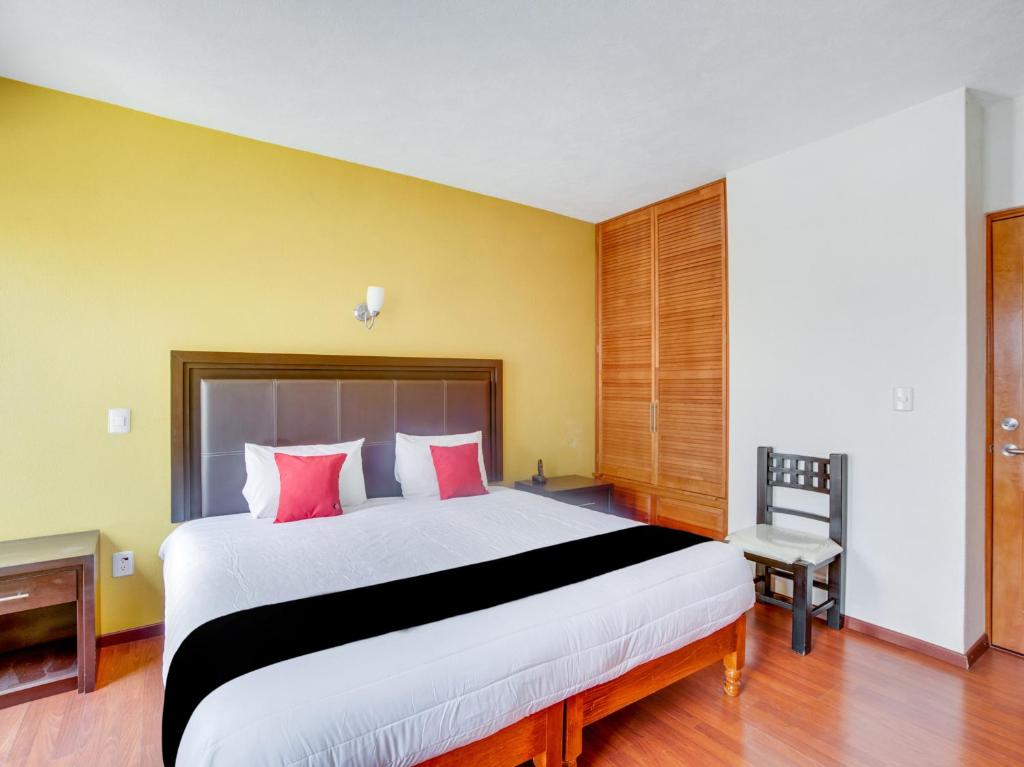 a bedroom with a large bed with red pillows at Hotel Patzcuaro in Pátzcuaro