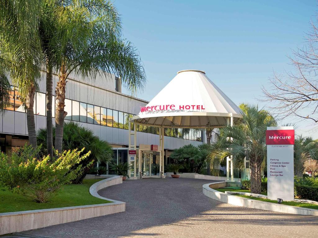 a hotel with a sign in front of a building at Mercure Roma West in Mostacciano 