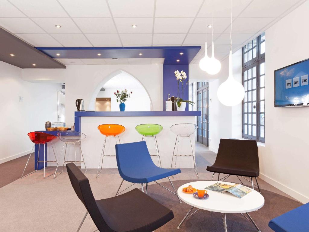 um quarto com cadeiras, uma mesa e um bar em ibis Styles Vannes Gare Centre em Vannes