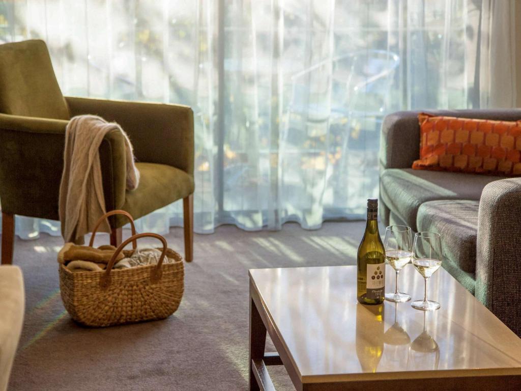 a living room with a bottle of wine on a table at The Sebel Launceston in Launceston