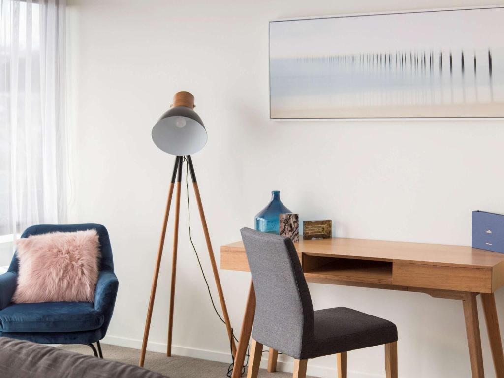 a room with a desk and two chairs and a lamp at The Sebel Launceston in Launceston