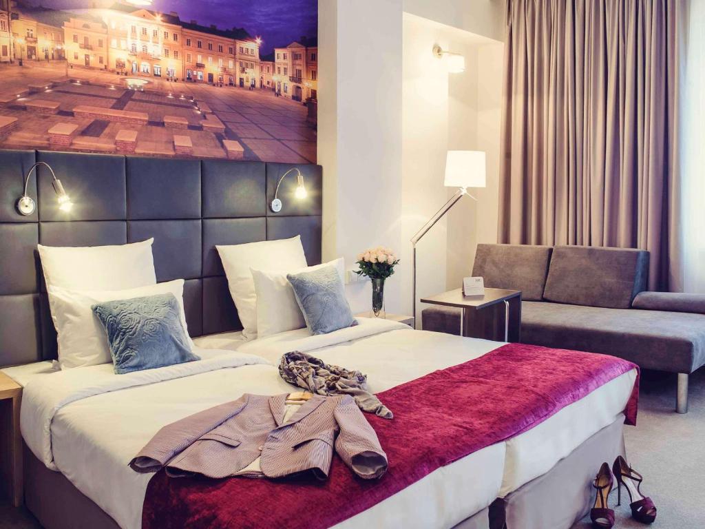 a hotel room with a large bed and a couch at Vestil Hotel in Piotrków Trybunalski