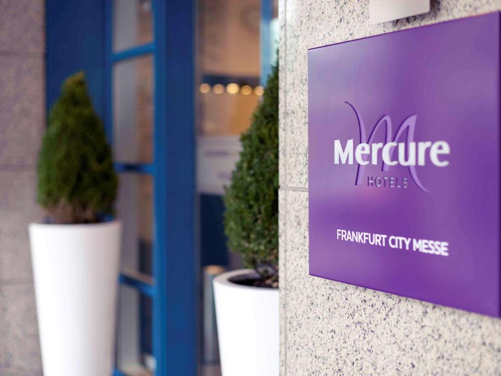 two potted plants sitting in front of a window at Mercure Frankfurt City Messe in Frankfurt