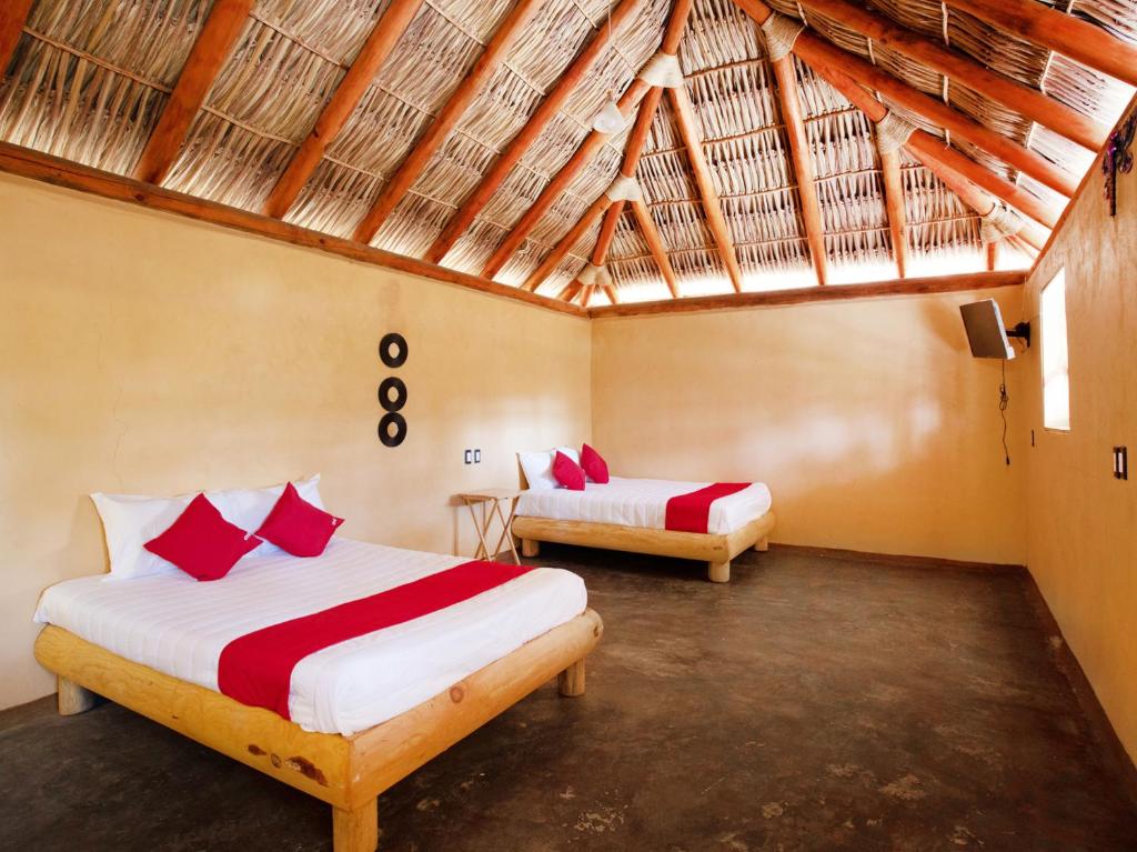 two beds in a room with a roof at Hotel Vista del Bosque, Villa del Carbón in Villa del Carbón