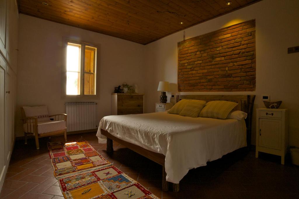 una camera con letto e muro di mattoni di B&B Casa Volton a Bevazzana