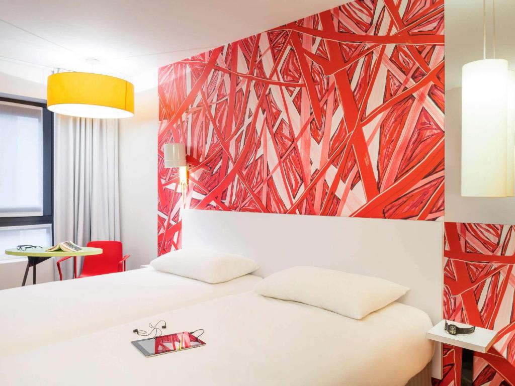 a bedroom with a white bed and a red wall at ibis Styles Paris La Défense Courbevoie in Courbevoie