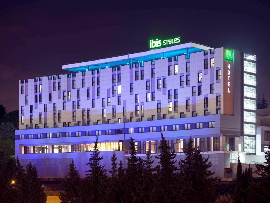 a large building with a sign on top of it at Ibis Styles Roma Eur in Rome