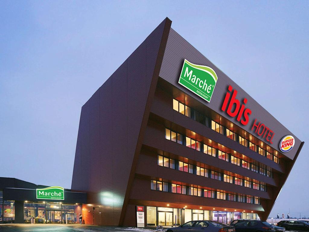 un gran edificio con un cartel de "nosotros" en él en Ibis Vienna Airport en Schwechat