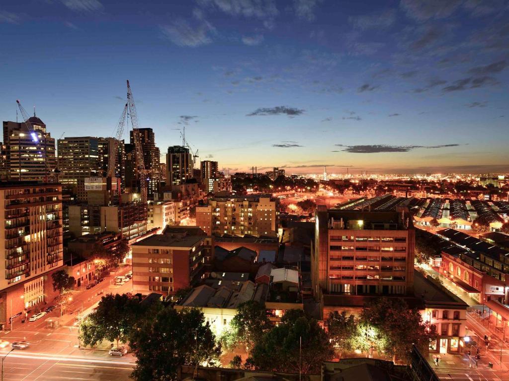 vistas a una ciudad por la noche con edificios en Mercure Melbourne Therry Street en Melbourne