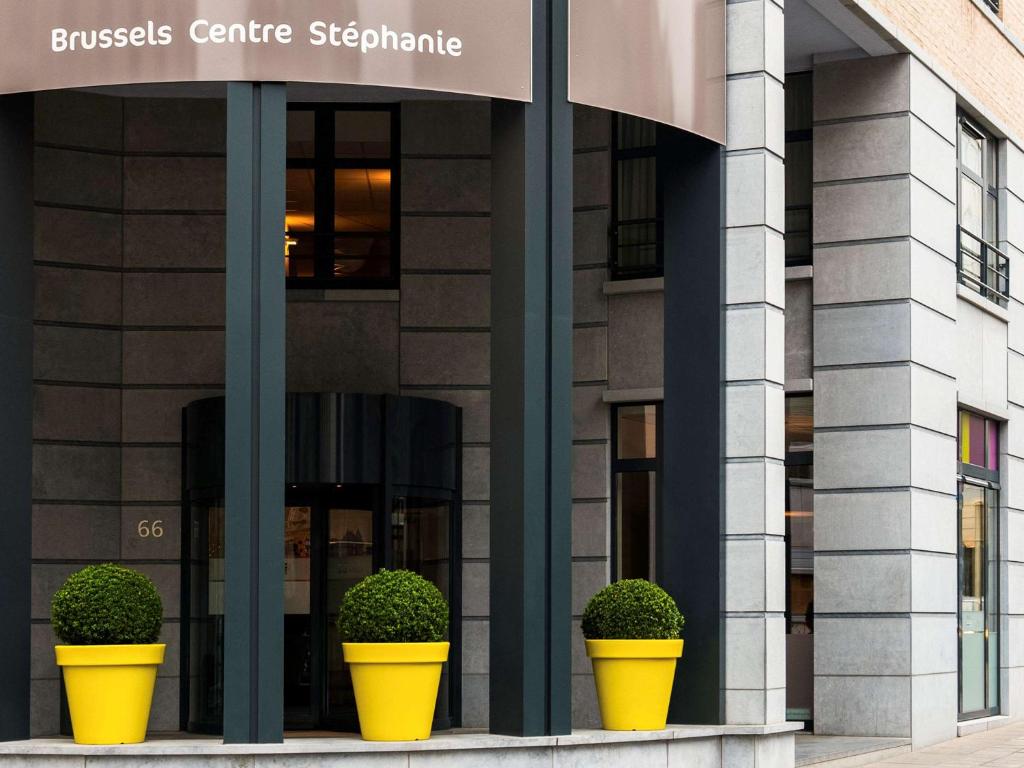 a building with three yellow pots in front of it at ibis Styles Hotel Brussels Centre Stéphanie in Brussels