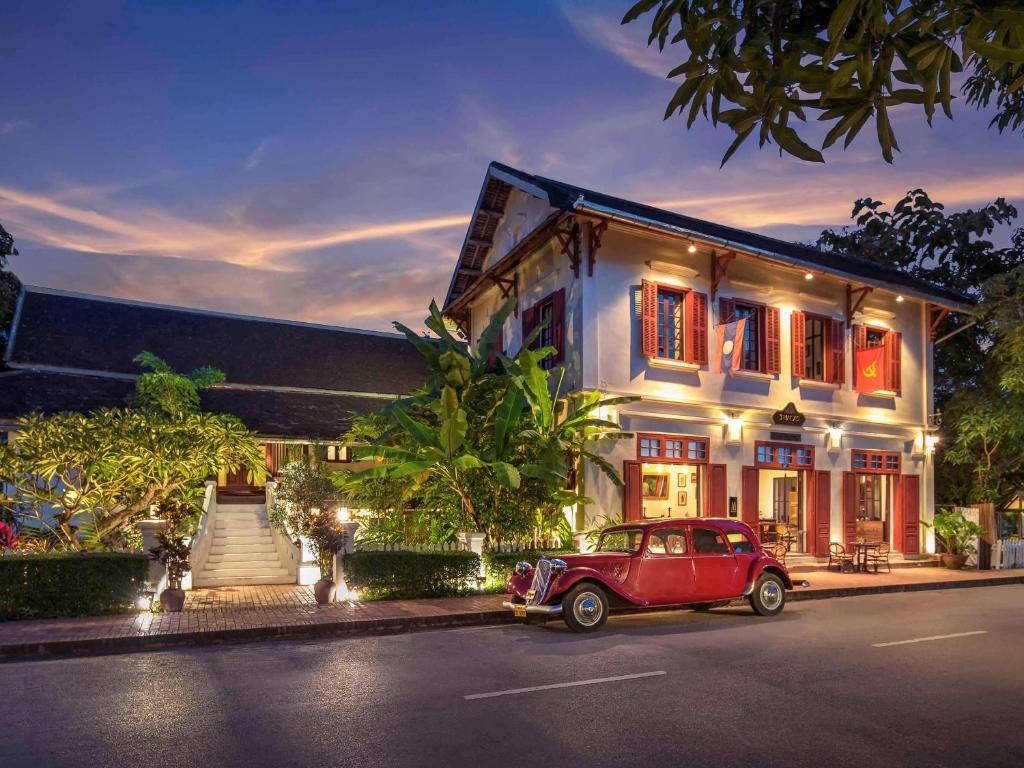 an old car parked in front of a building at 3 Nagas Luang Prabang - MGallery Hotel Collection in Luang Prabang