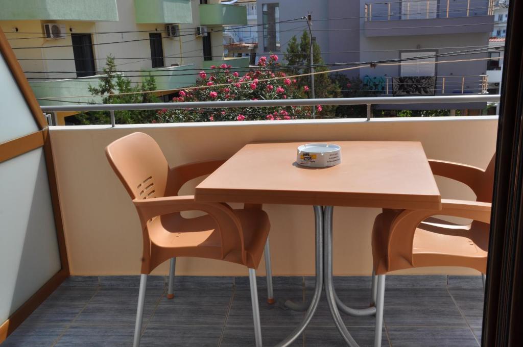 een tafel en stoelen op een balkon met bloemen bij Villa Edi&Linda in Ksamil