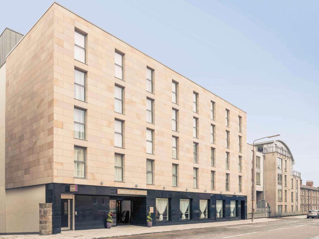 a large brick building on the corner of a street at Mercure Edinburgh Haymarket in Edinburgh