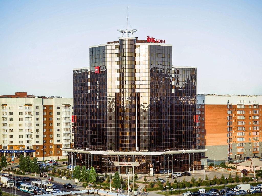 a tall building with many windows in a city at Ibis Astana in Astana