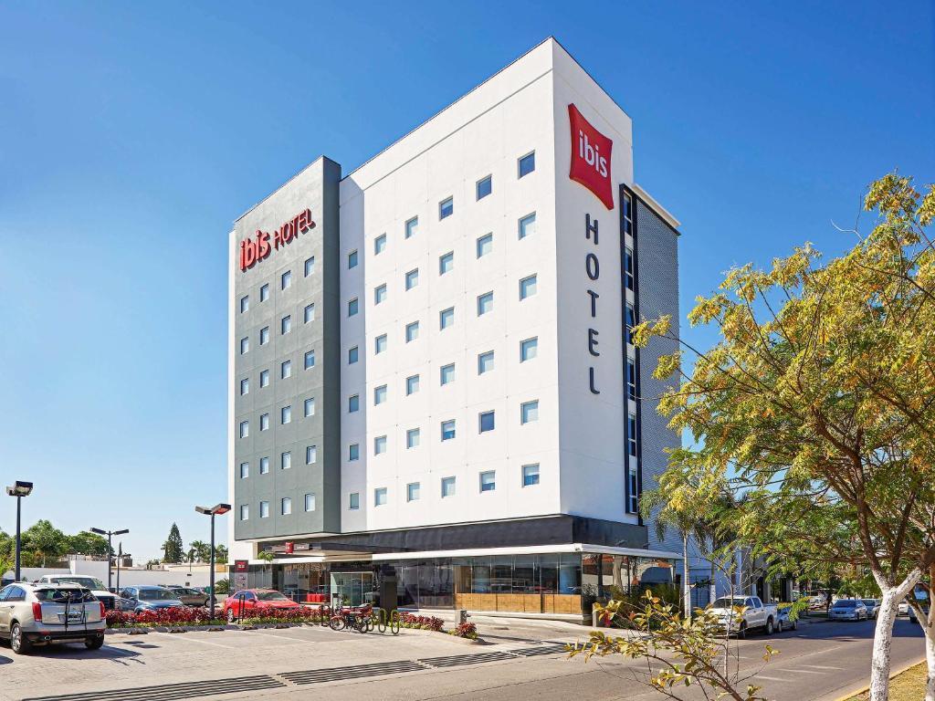 un grand bâtiment blanc avec un hôtel rouge dans l'établissement Ibis Los Mochis, à Los Mochis