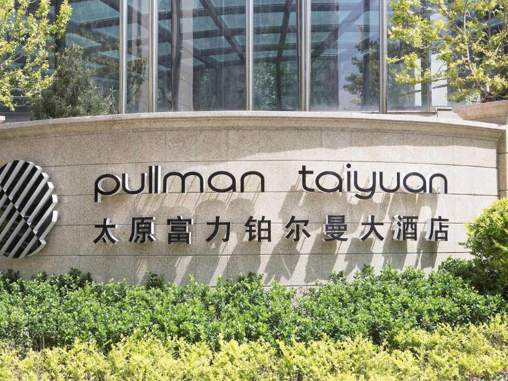 una señal de aumanji tokyo frente a un edificio en Pullman Taiyuan en Taiyuán