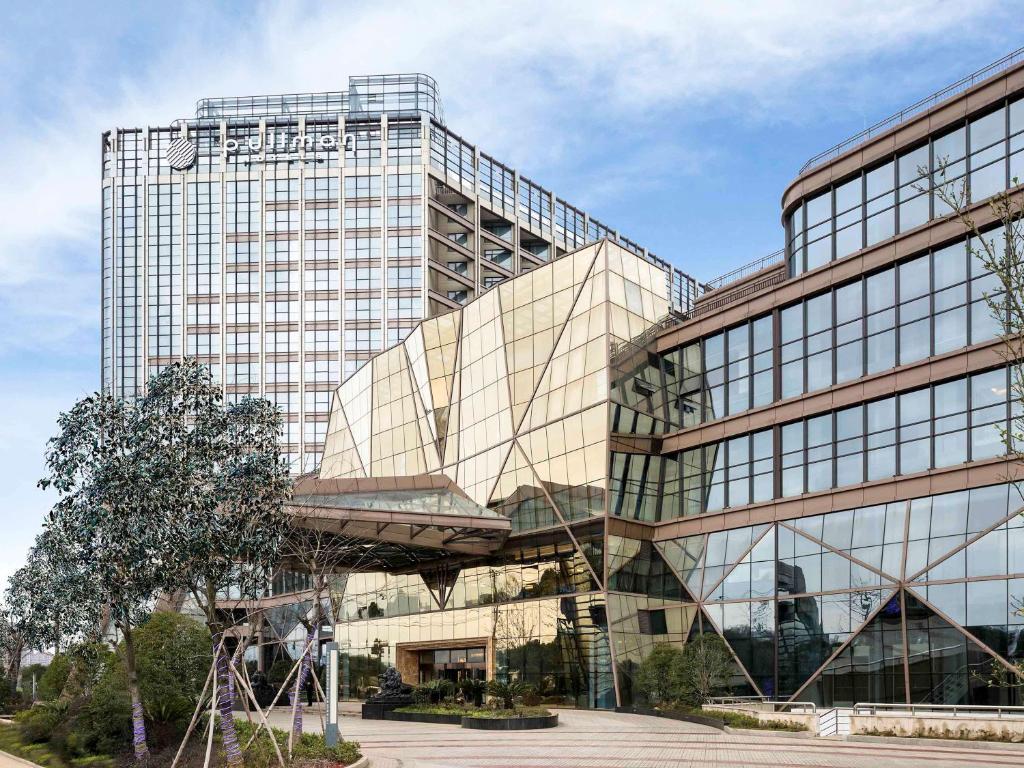 a large glass building with a sign on it at Pullman Wenzhou in Wenzhou