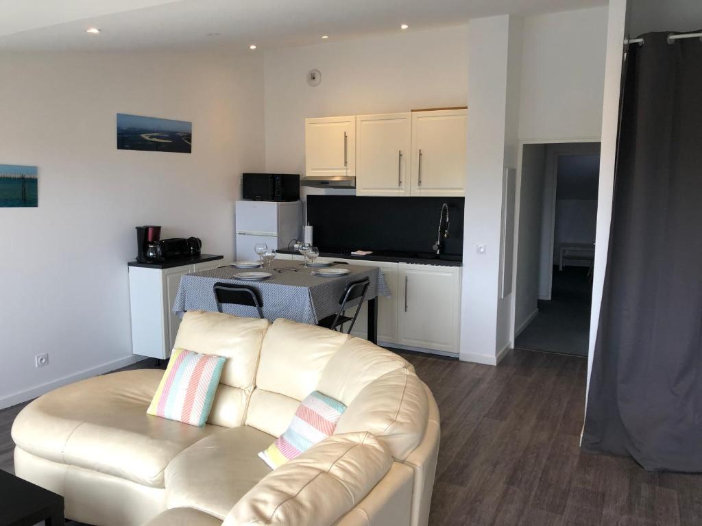 a living room with a couch and a kitchen at Les Locations du Bassin Appartements Alexandre in La Teste-de-Buch