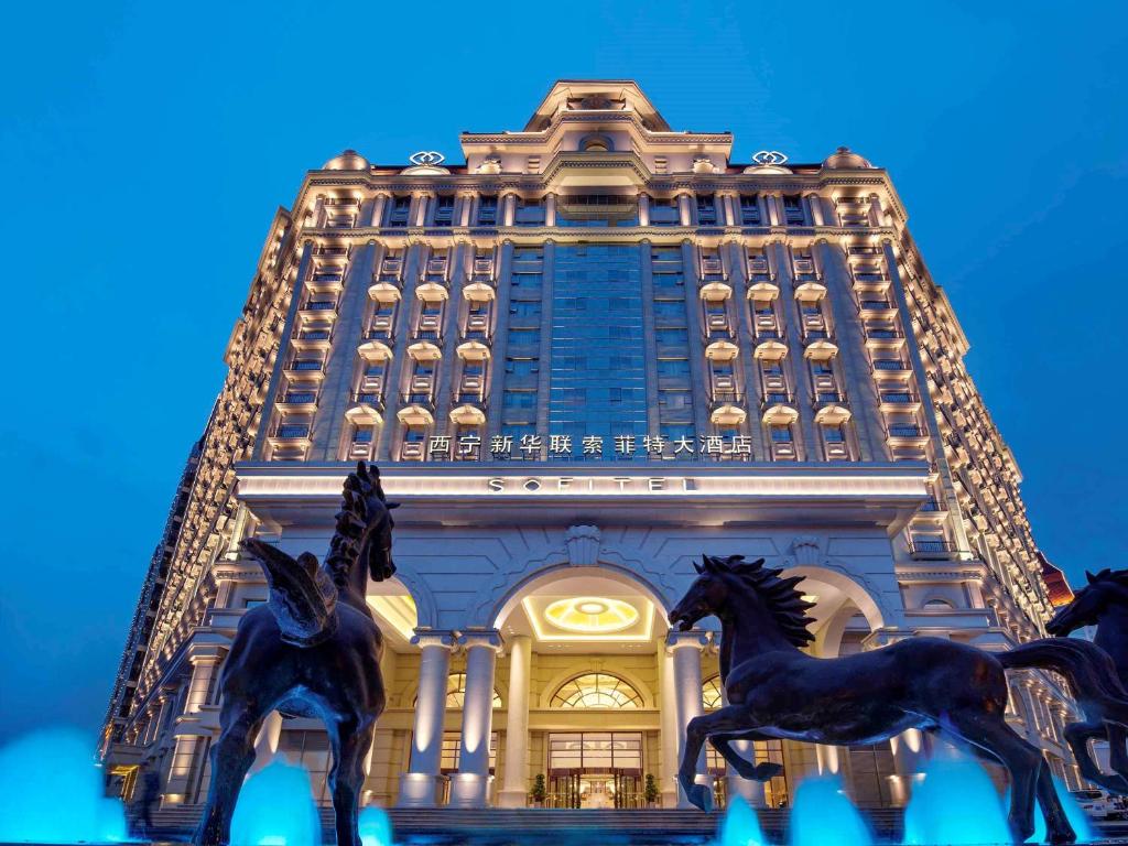 a tall building with horses in front of it at Sofitel Xining in Xining