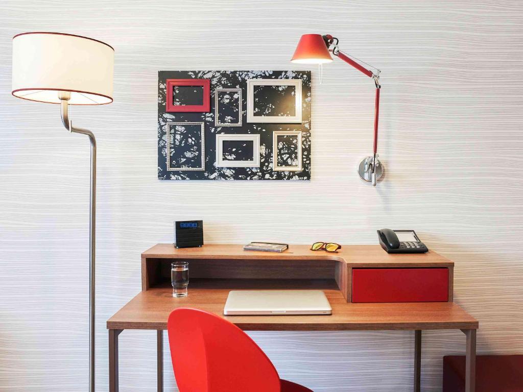 an office with a desk with a lamp and a red chair at Aparthotel Adagio Birmingham City Centre in Birmingham