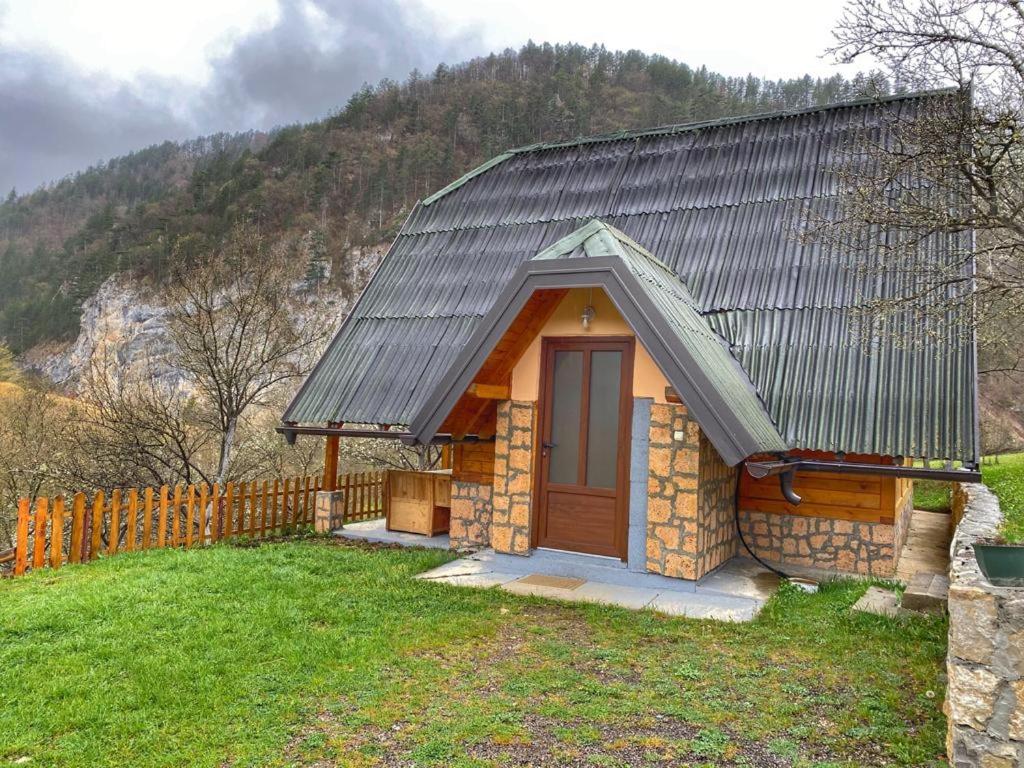 une petite maison avec une porte marron et une clôture dans l'établissement Vikendica NEVEN, à Zaovine