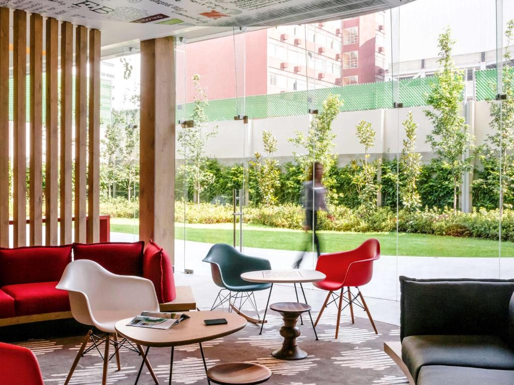 a lobby with chairs and tables and a large window at Ibis Mexico Alameda in Mexico City