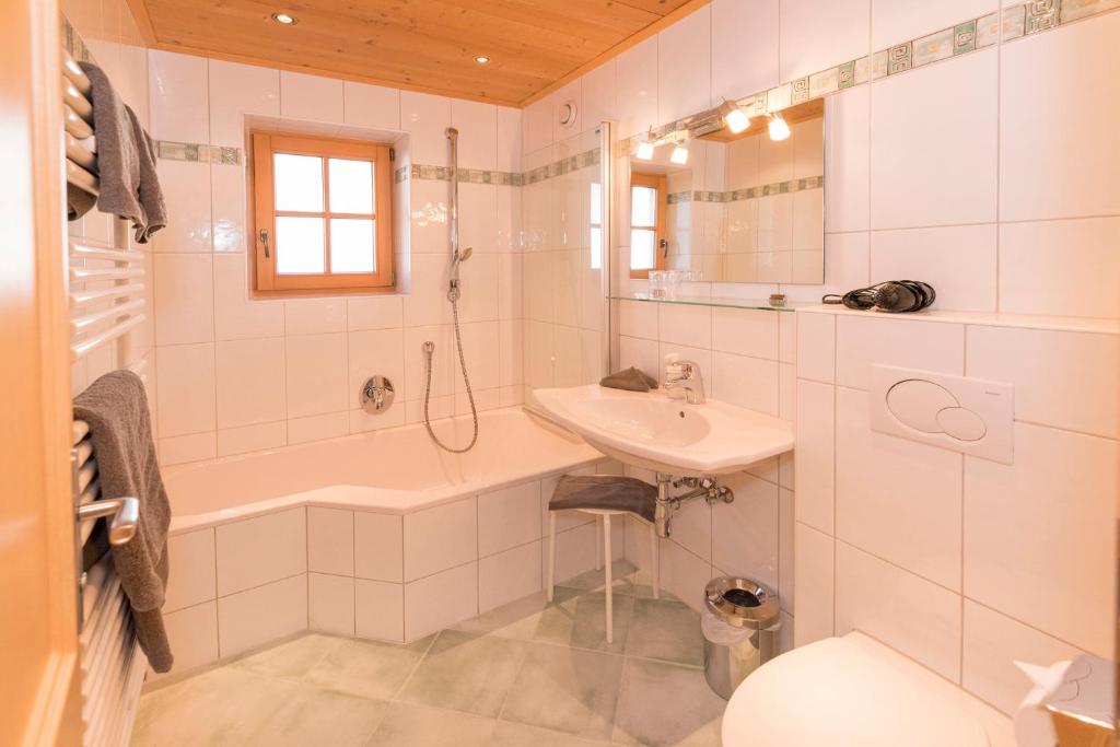 a bathroom with a sink and a tub and a toilet at Das kleine, feine SONNWEND in Alpbach