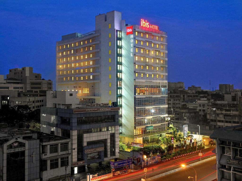 ibis Chennai City Centre - An Accor Brand في تشيناي: مبنى مضاء في مدينة في الليل