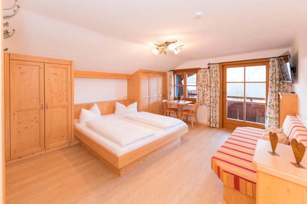 a bedroom with a large bed and a table at Das kleine, feine SONNWEND in Alpbach