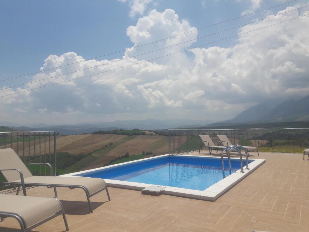 - une piscine avec des chaises et une vue sur la montagne dans l'établissement Casa Con Vista Holiday Rentals, Honeysuckle, à Guardiagrele