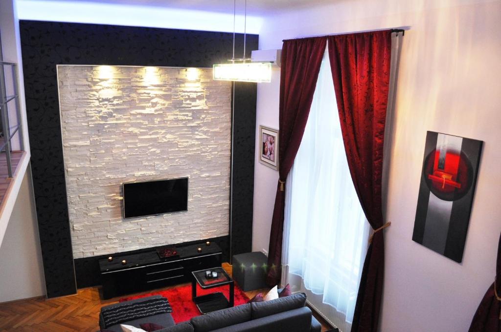 a living room with a stone wall with a tv at Welcome Budapest Apartments in Budapest