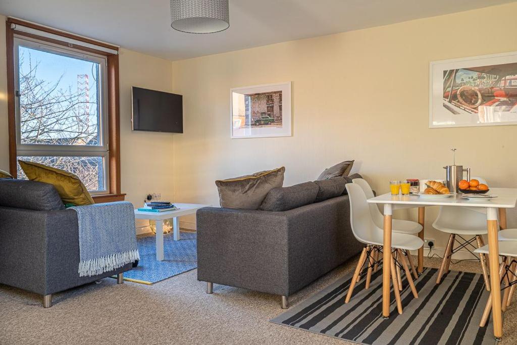- un salon avec deux canapés et une table dans l'établissement Broughty Ferry Apartment, à Dundee