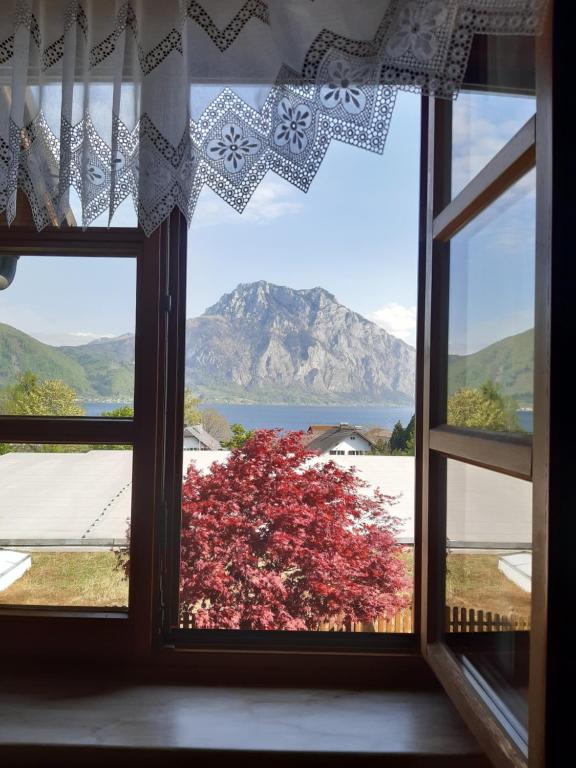an open window with a view of a mountain at Apartment See und Traunsteinblick in Altmünster