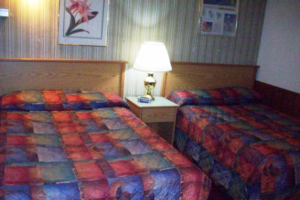 a hotel room with two beds and a lamp at Hilander Motel in Mountain Home