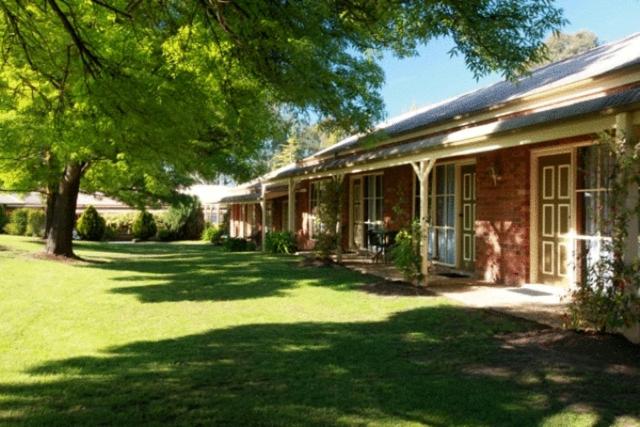 ein Haus mit einem Rasenplatz davor in der Unterkunft Mansfield Valley Motor Inn in Mansfield