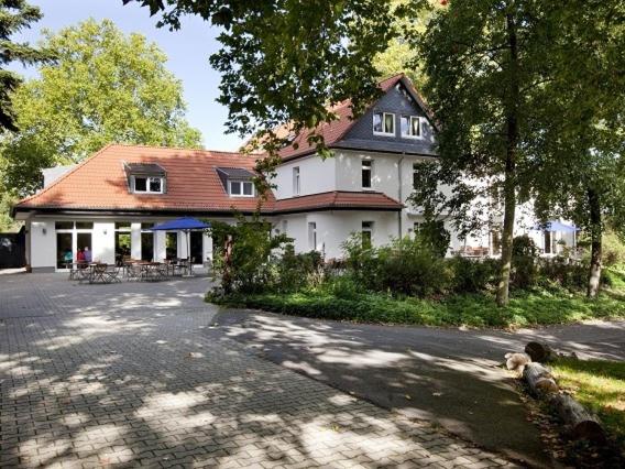 une grande maison blanche avec un toit rouge dans l'établissement Haus Müllestumpe, à Bonn