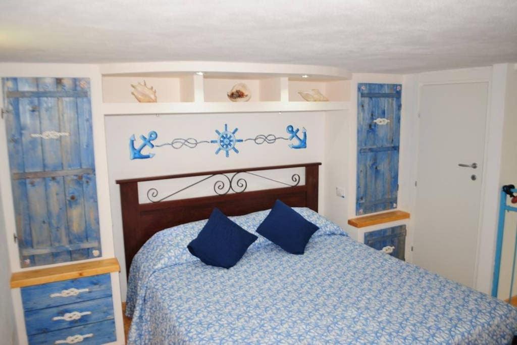 a bedroom with a blue bed with blue pillows at Stella Marina in Gaeta