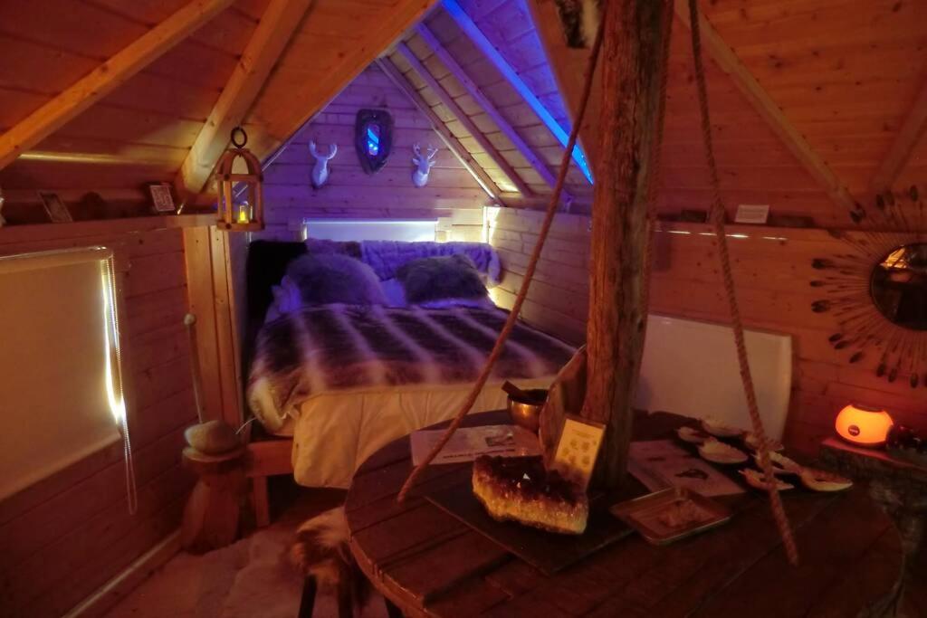 a bedroom with a bed in a room with a ceiling at KOTA Finlandais bien être , les gîtes de l'étang in La Chapelle