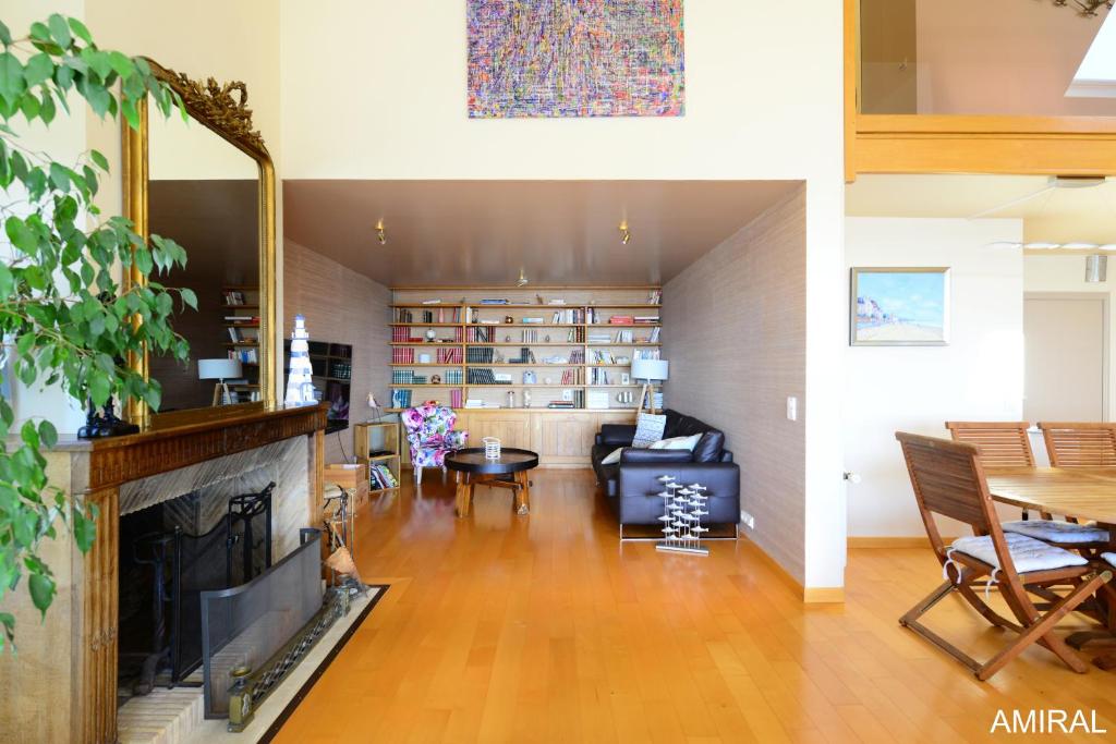 a living room with a fireplace and a couch at Aux Premières Loges in Fécamp