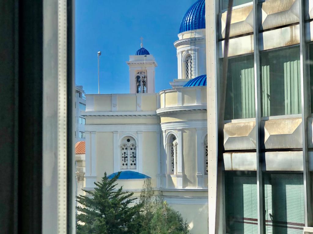ein weißes Gebäude mit blauen Kuppeln darüber in der Unterkunft Royal Blue Grand Suite No 3 in Piräus