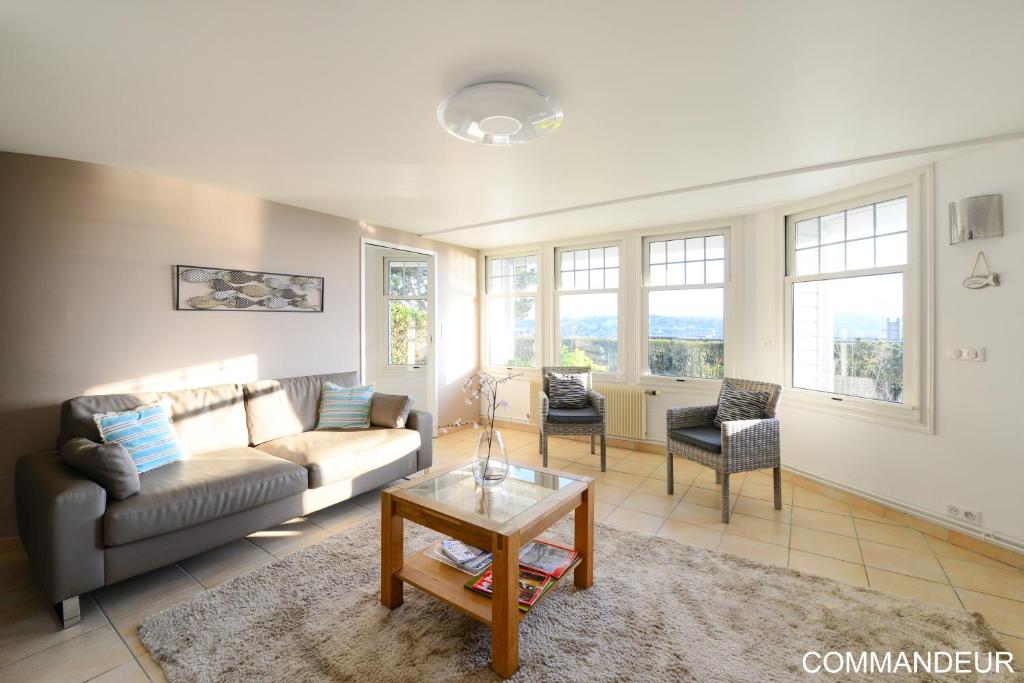 a living room with a couch and a table at Aux Premières Loges in Fécamp